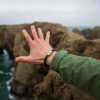 Ausgestreckte Hand Richtung Meer, mit Armband Makrele Segeltau von Fischers Fritze