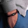 Handgelenk mit dunkelrotem Fischers Fritze-Armband, Torpedomakrele Magnetverschluss schwarz mit Edelstahl-Gravur